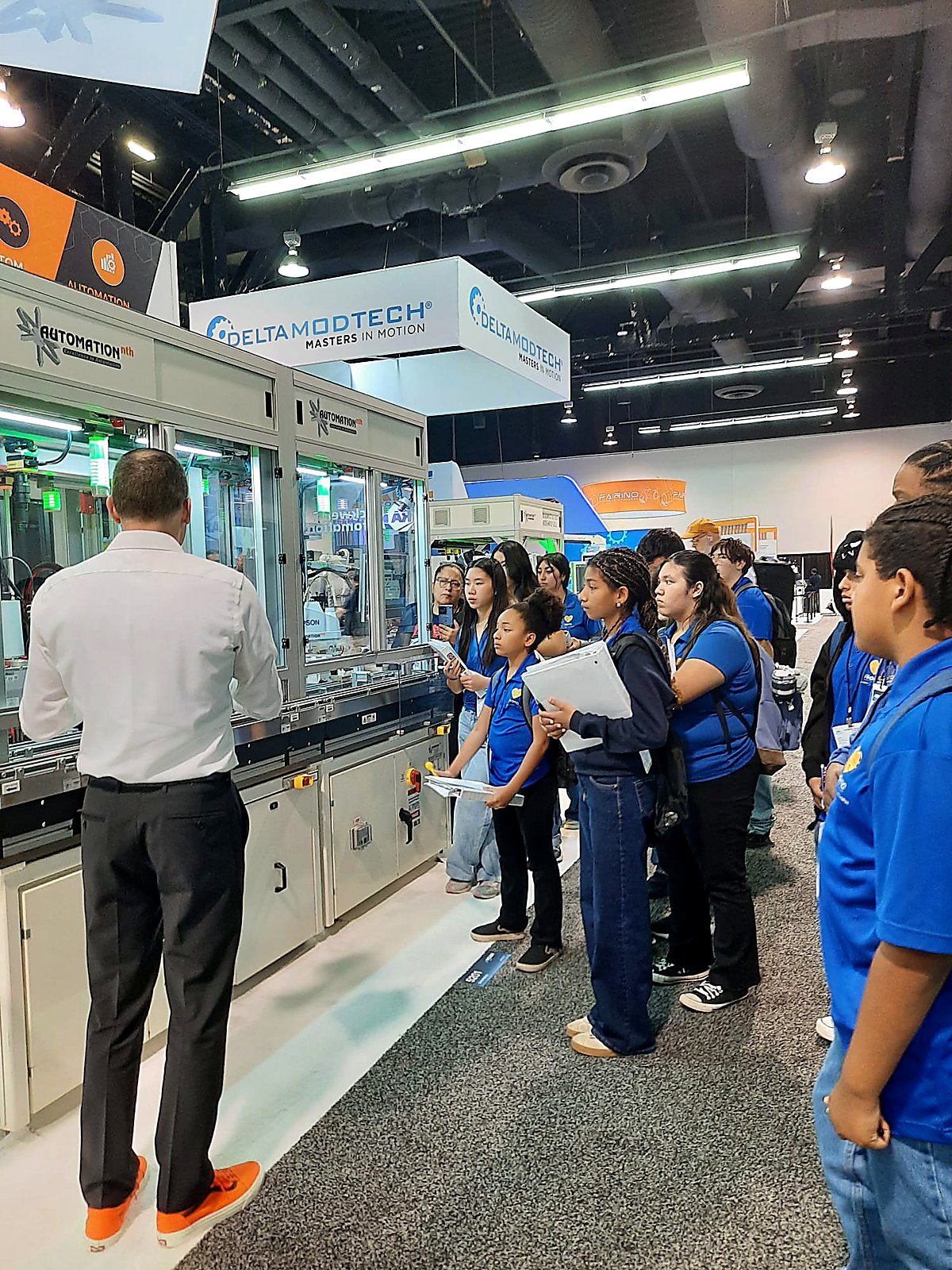 DAYP cohort listening to an Automation Nth engineer explain an automated production line at MD&M West